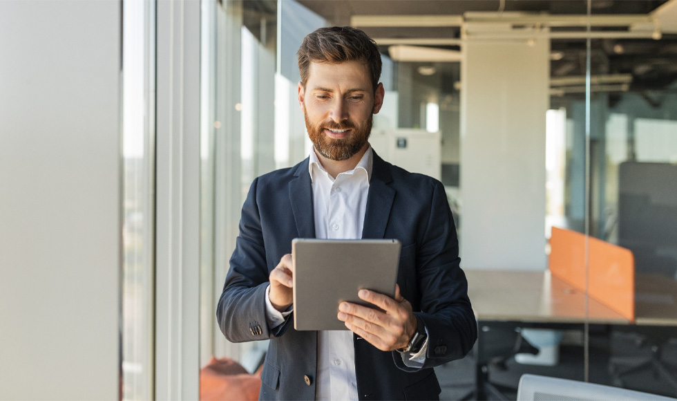 Man working on a tablet while standing in a modern office
