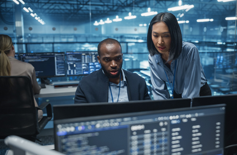 Colleagues working on a laptop in a data centre