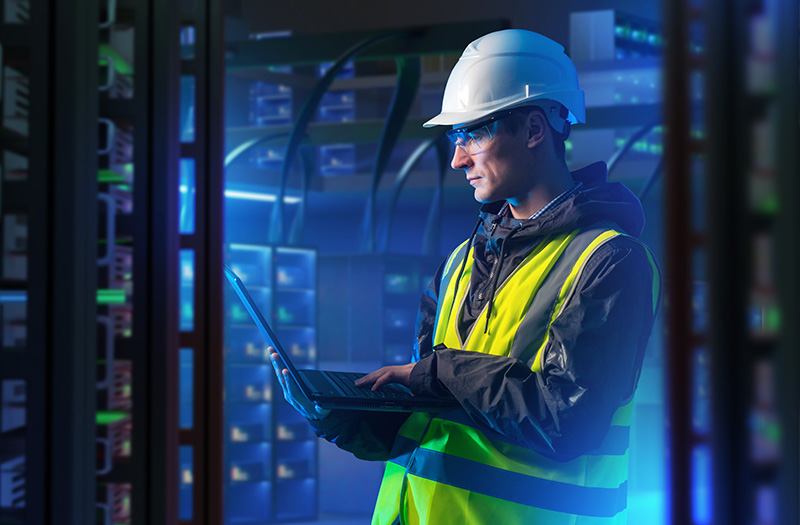 Man in server room working on laptop