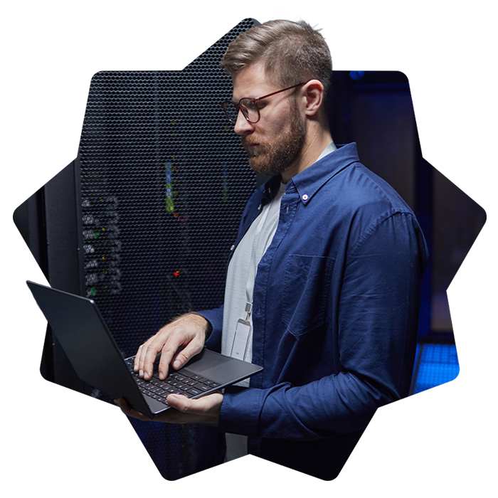 Man working on laptop in server room