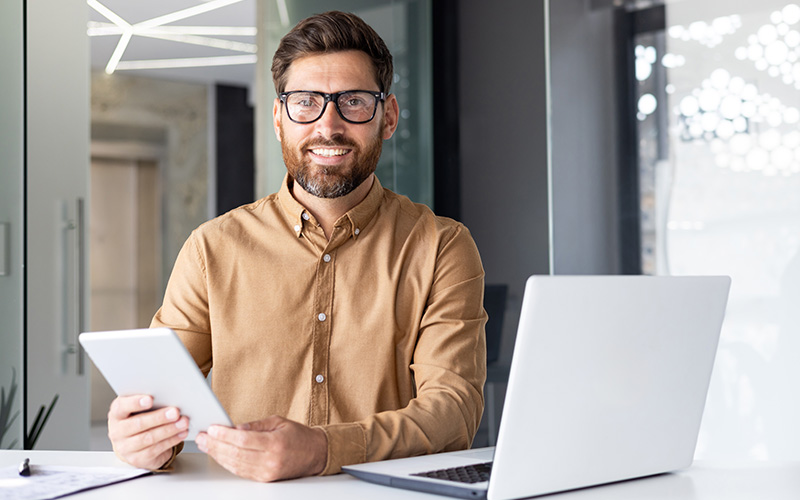 Man smiling holding tablet
