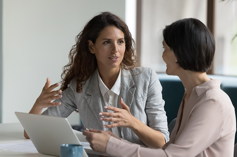 Reduce SAP Costs. Control Your Compliance. Two colleagues sharing a document