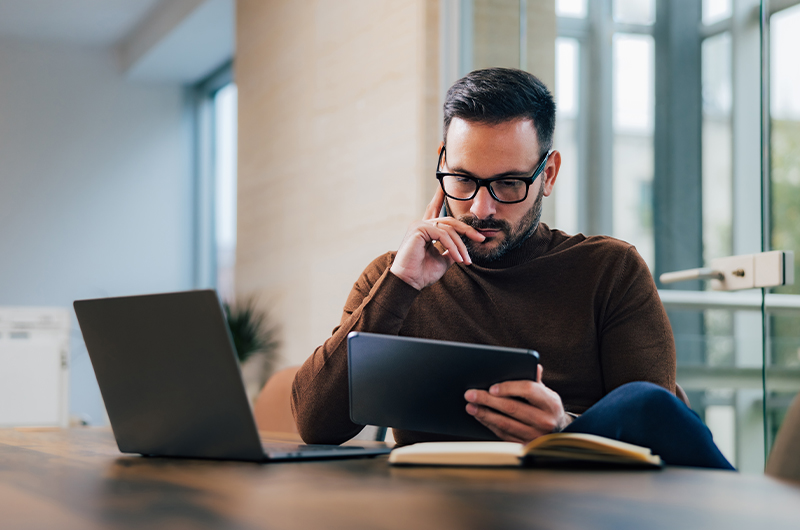 Man working on a tablet and laptop