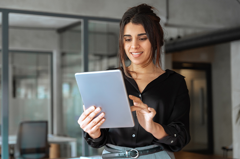 Woman smiling while working on a tablet