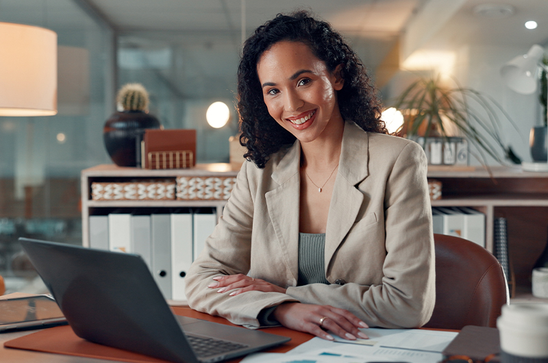 Woman working at a desk while smiling