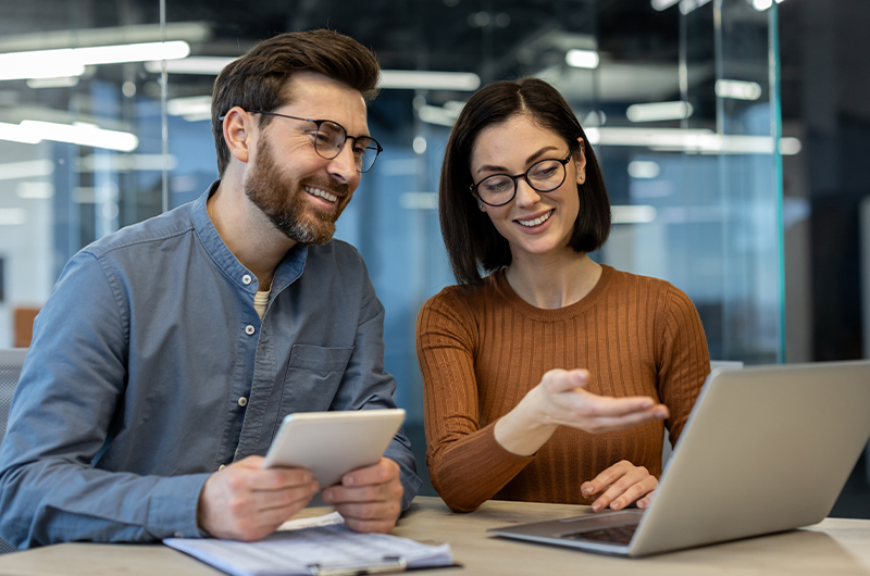 Two colleagues working together on a laptop