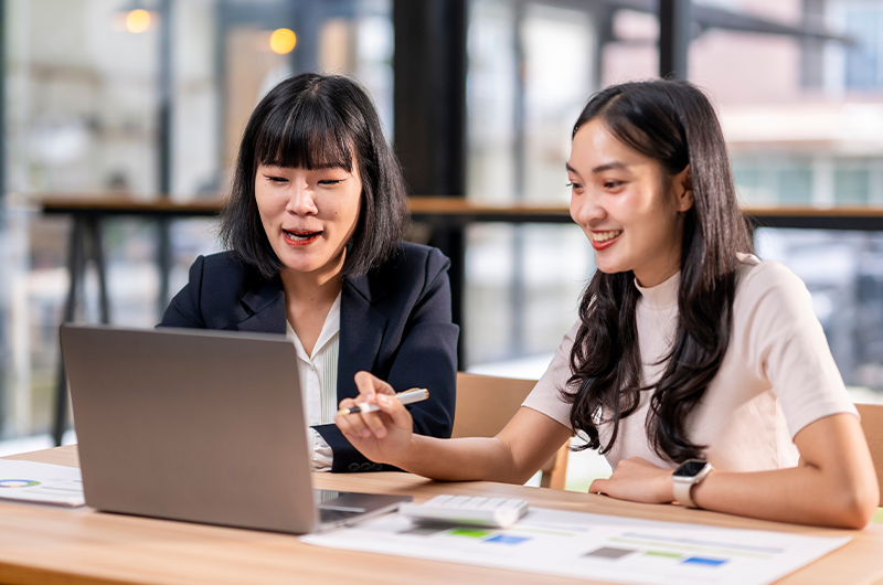 Two women working together on a laptop