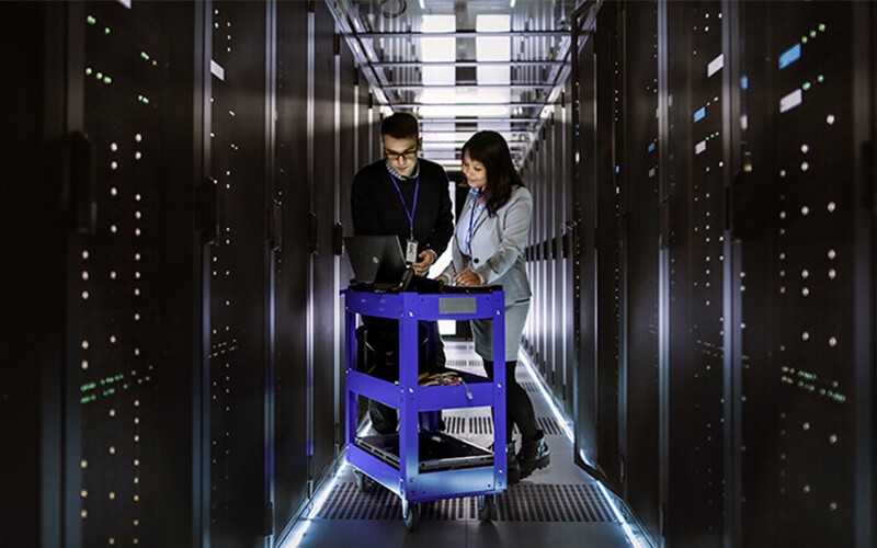 Two employees in a server room