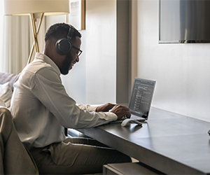 Man sat down using a Surface Laptop 5