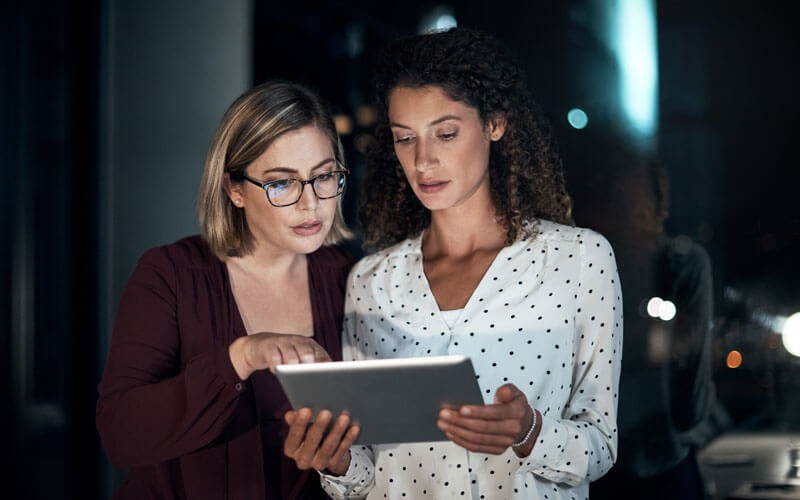 Two woman looking over tablet device