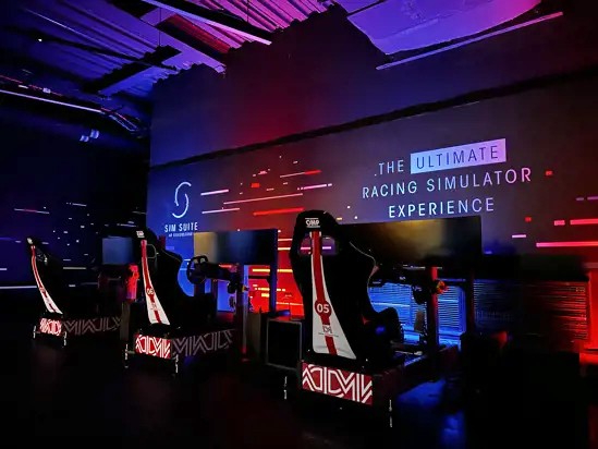 Immersive racing booth at Silverstone Museum, showcasing steering wheel and pedals for an authentic racing experience.
