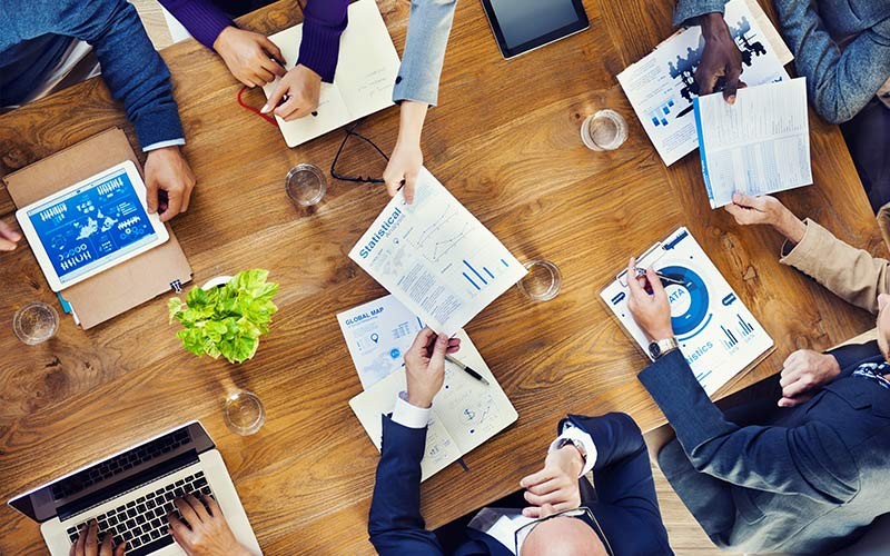 Give your workforce access to Mac Group of employees around a table