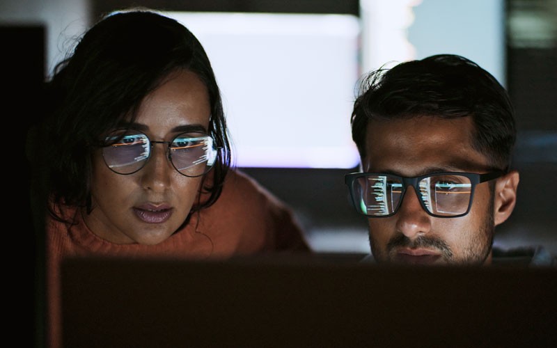 Cisco Umbrella helps you save time and minimise security costs. Two IT security engineers using Cisco Umbrella on desktop computer