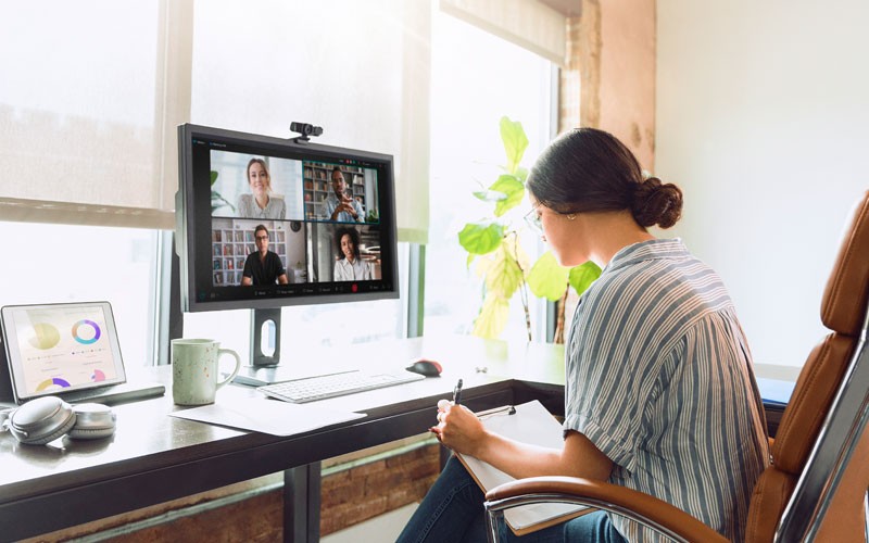 Woman taking notes while on a video call Woman taking notes while on a video call