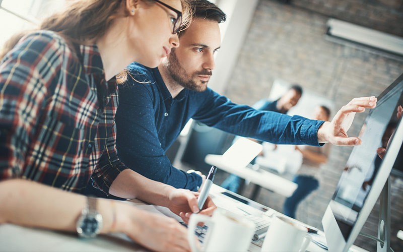 Speed up your Mac system Two colleagues working on a Mac