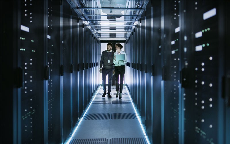 Ensure essential data protection Two technicians walking through a data centre