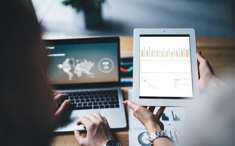 Monitor and manage power devices with Eaton. IT technicians assessing data on laptops