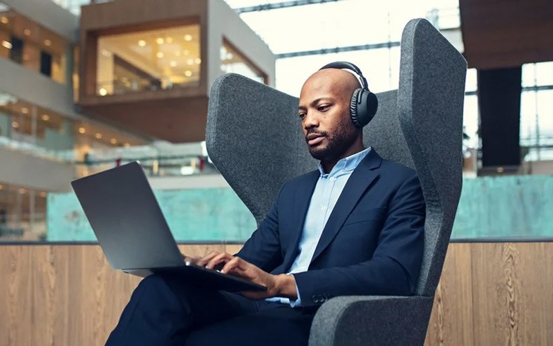 Discover EPOS | SENNHEISER headsets Man working in an open space with a headset on