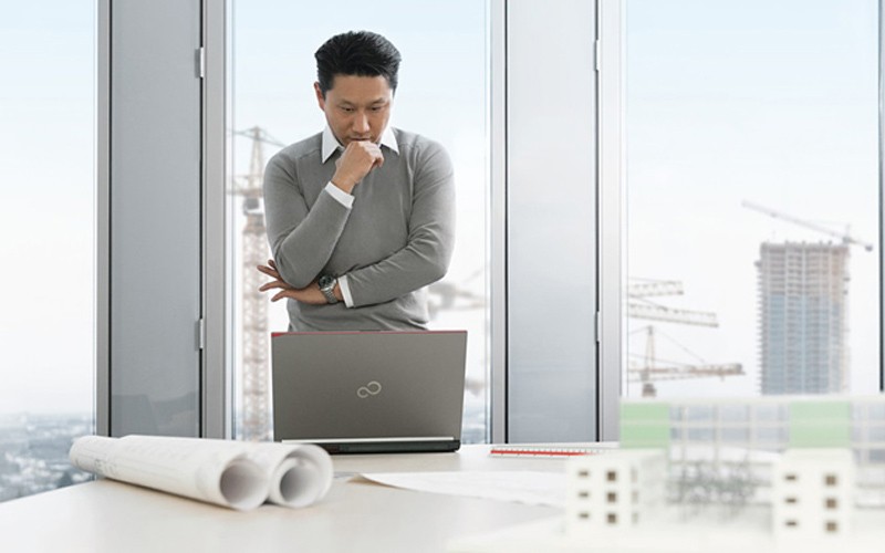 LIFEBOOKs support your business with entry-level and powerful individual solutions Man thinking while looking down at a notebook