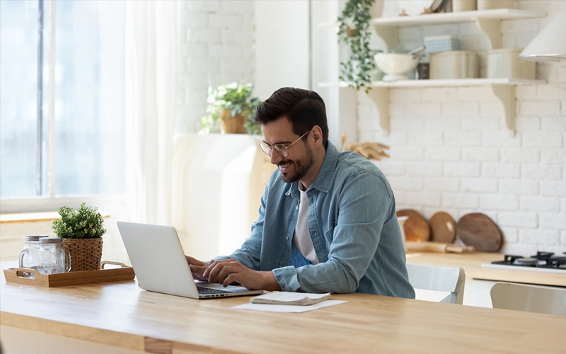 Intelligent automation man working at laptop in kitchen