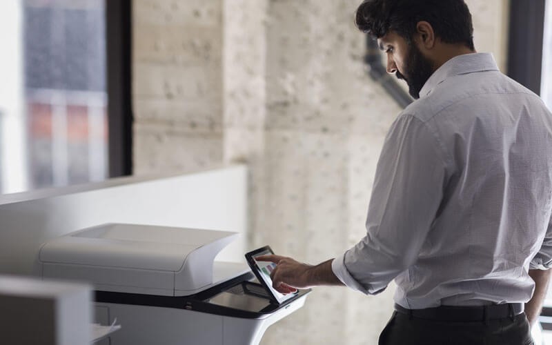 Protect your print and imaging endpoints Man using the touch-screen of a HP printer