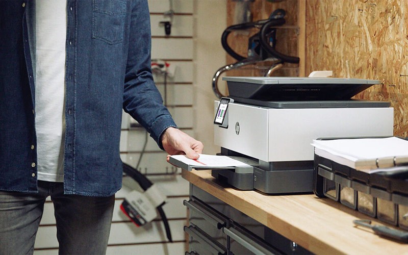 Man collecting printed forms from the tray