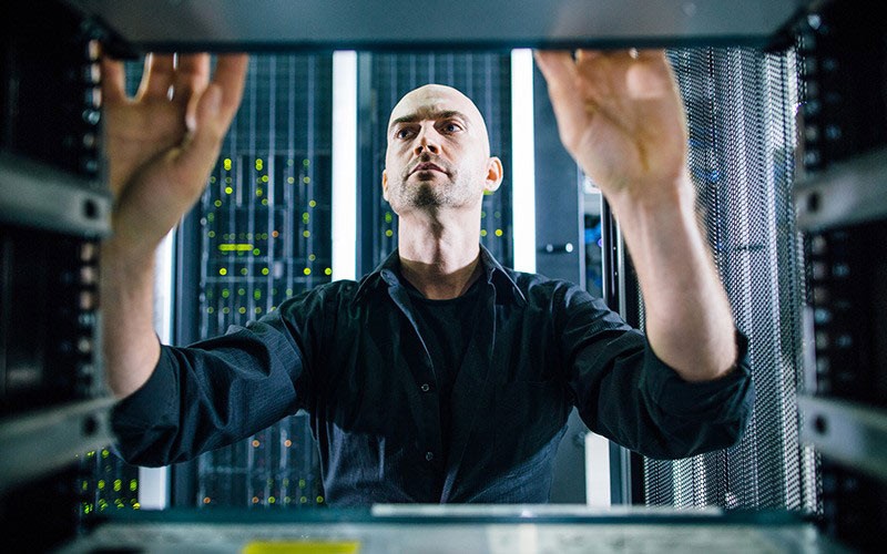 IT technician working on server racks found in data centre