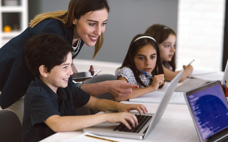 Teacher with students on notebook computers