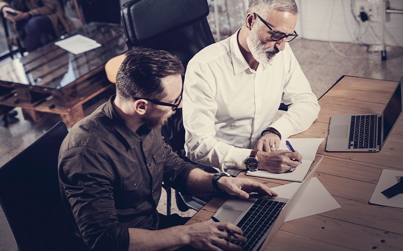 Keep up with the pace of business Two men working on a laptop