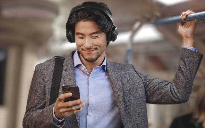 Man using headphones and looking at phone