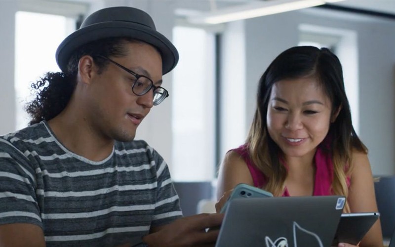 Jamf Security, Privacy & Compliance Two people with a laptop and phone