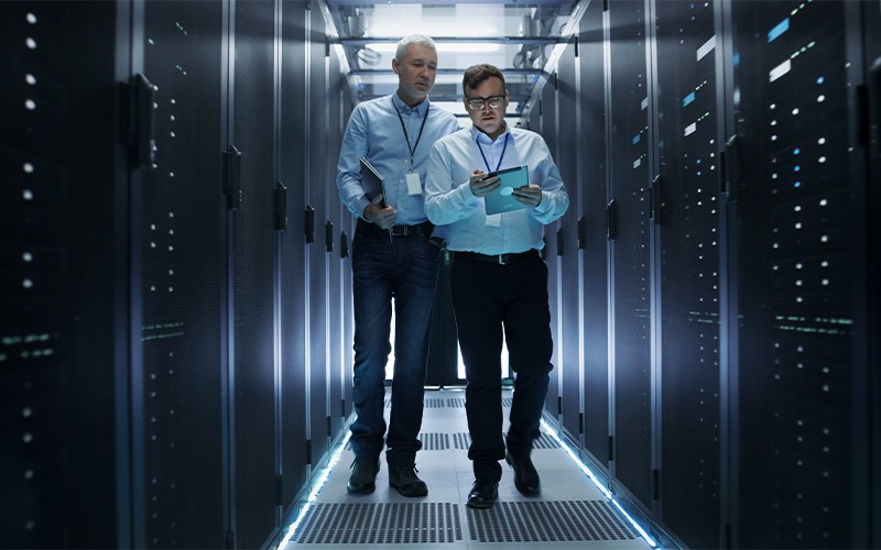 two colleagues walking through a data centre