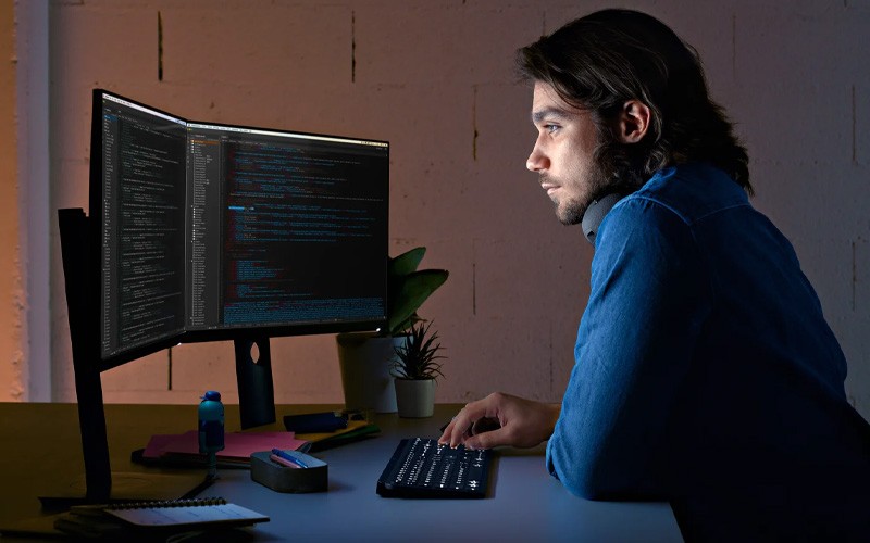 Man using MX Keys keyboard at night.