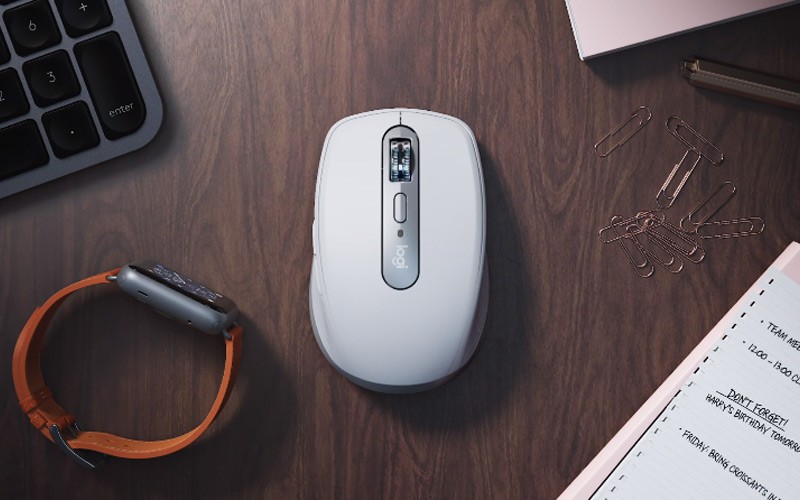 Logitech MX mouse on a desk next to a watch