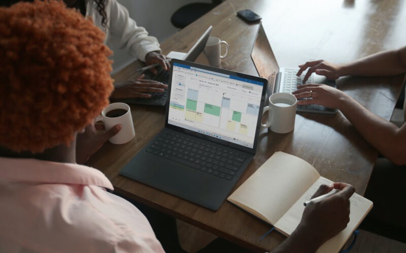 3 people working together on microsoft surface devices