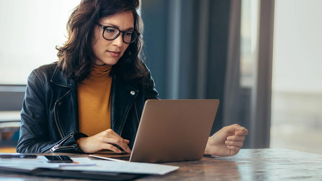 woman concentrating on presentation on laptop woman concentrating on presentation on laptop