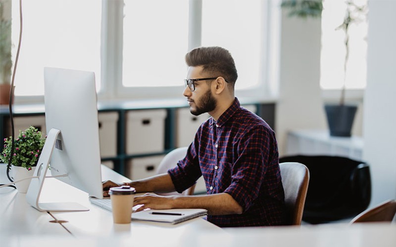 man typing on keyboard with cloud security symbol