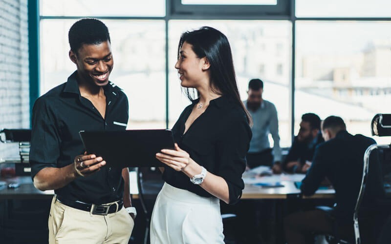 See real-time system status and receive immediate alerts Two colleagues looking down at a tablet