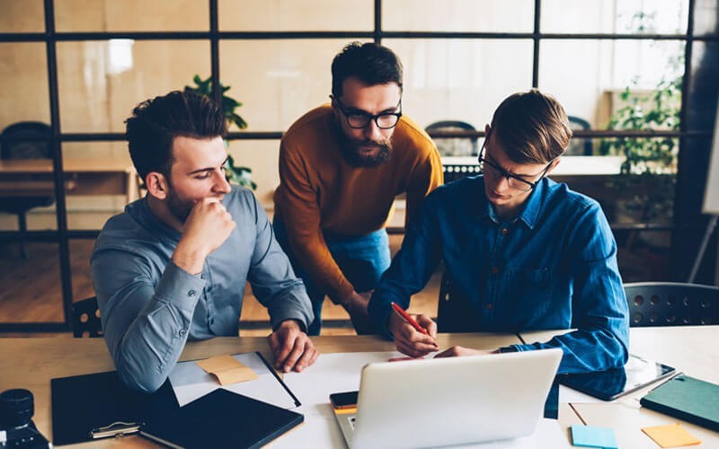 Access to hundreds of certified technology partners Group of casually dressed colleagues gathered around laptop in startup office