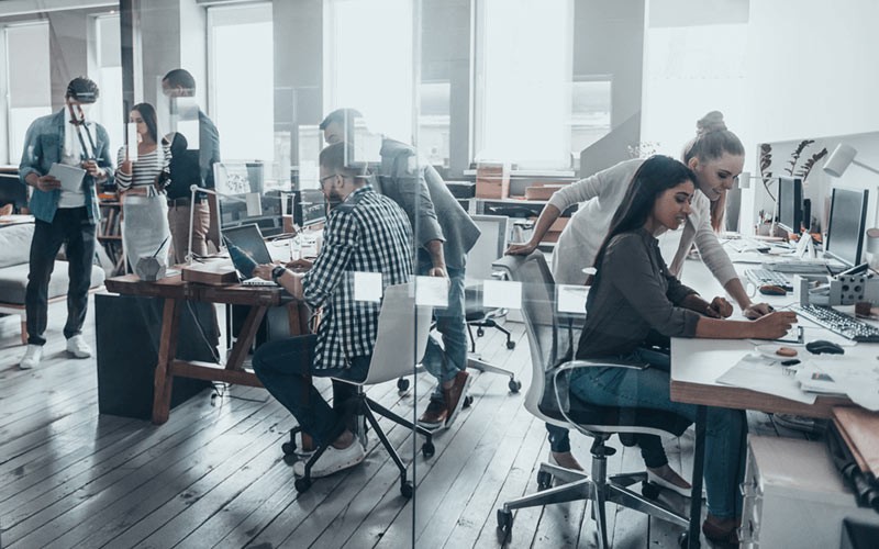 Various businessmen and women working in modern open office