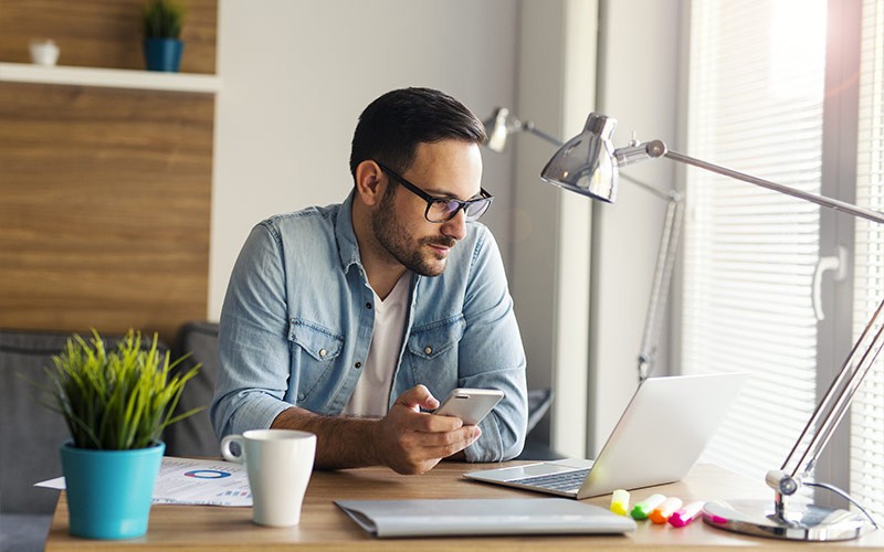Man working from home while using mobile device