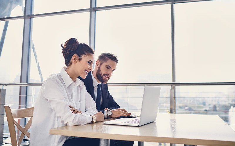 Justify the Cost of the Migration Two colleagues working together on a laptop