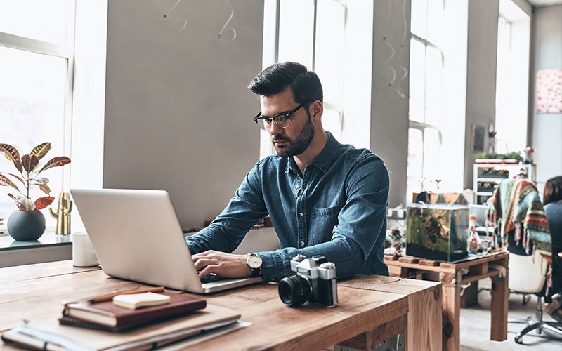 Casually dressed man working on a laptop