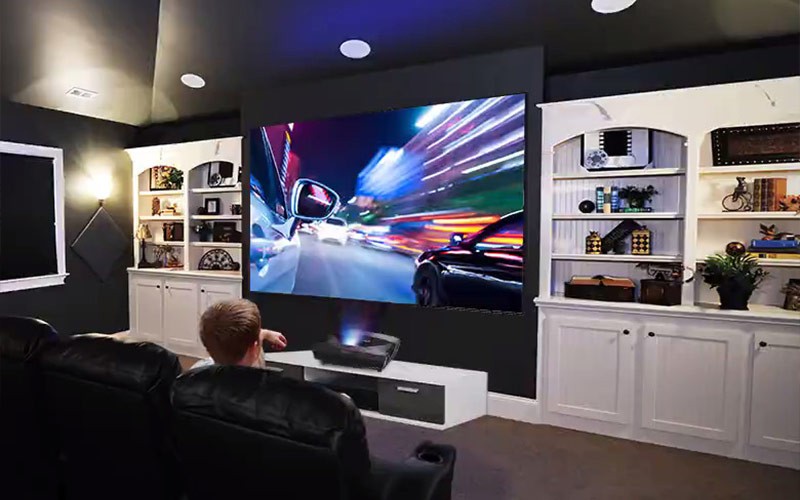 Shine in any environment Man sitting on a sofa in front of a Viewsonic projector