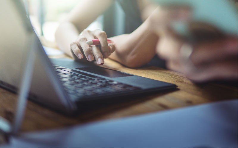 Woman using trackpad on laptop