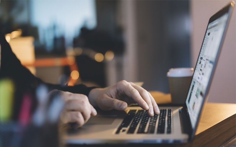 User typing on laptop keyboard